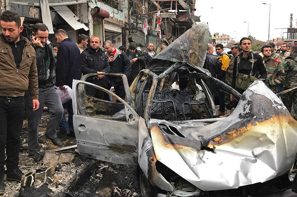 Warga melihat mobil yang hancur akibat ledakan bom bunuh diri di Jableh.