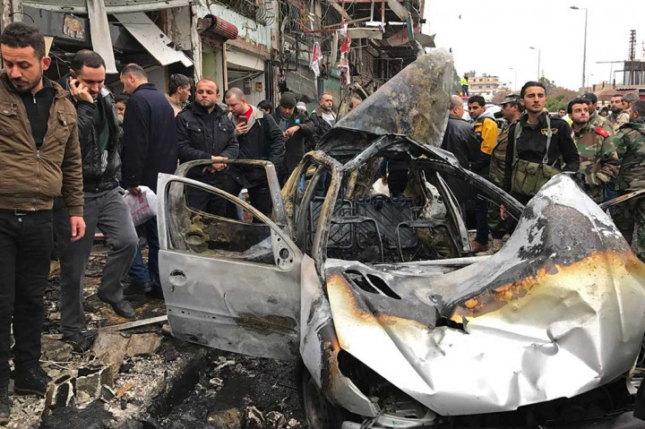 Warga melihat mobil yang hancur akibat ledakan bom bunuh diri di Jableh.