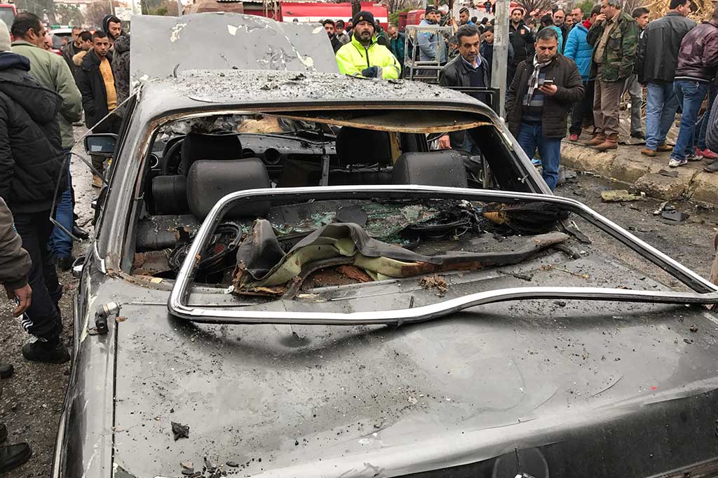 Warga melihat mobil yang hancur akibat ledakan bom bunuh diri di Jableh.