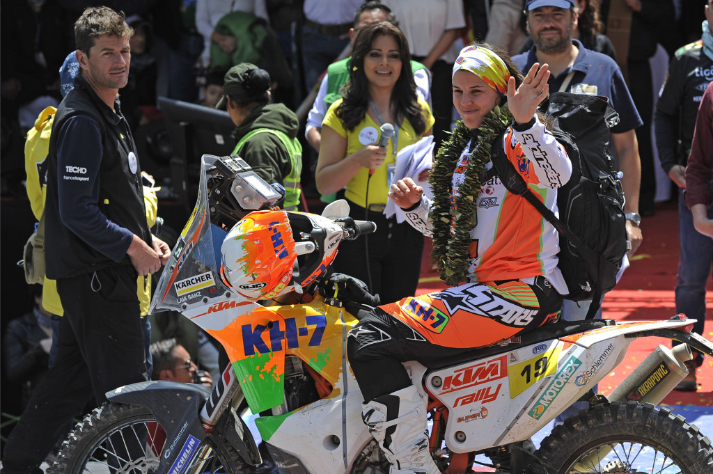Laia Sanz menyapa warga La Paz yang menyambutnya. Warga negara Spanyol andalan tim KTM Racing ini adalah satu dari sedikitwanita pernah yang mengikuti reli ganas ini. AFP Photo/Jorge Bernal