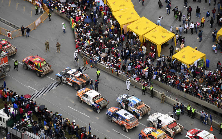 Rangkaian mobil peserta berparade di La Paz, Bolivia. Hingga rute alternatif tersedia, peserta tertahan di kota yang dikelilingi gunung ini.