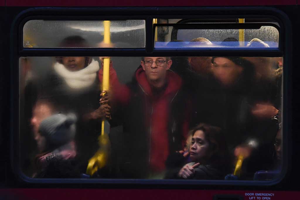 Calon penumpang komuter berdesakan di dalam bus.