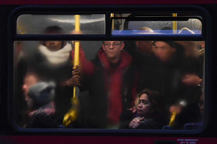 Calon penumpang komuter berdesakan di dalam bus.