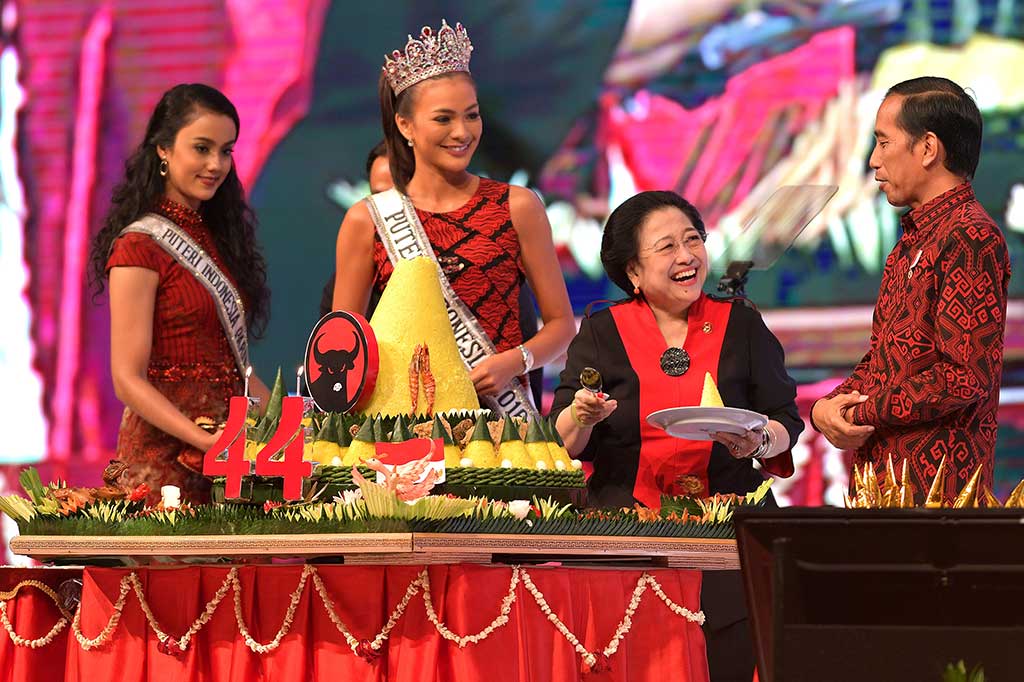 Ketua Umum PDIP Megawati Soekarnoputri memotong tumpeng dan diserahkan kepada Presiden Jokowi.