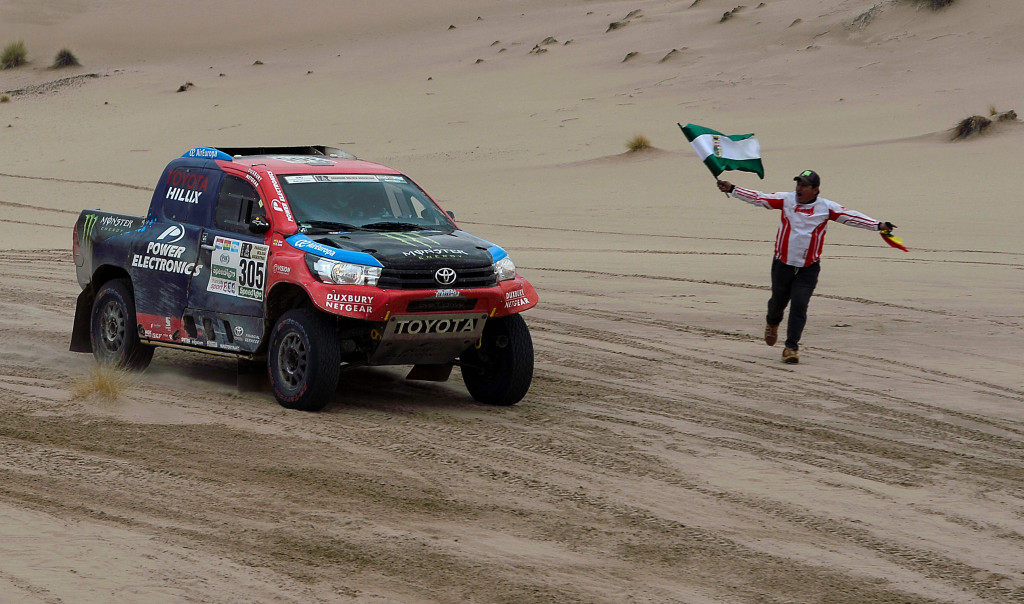 Warga menyemangati Nani Roma and Alexandre Haro Bravo yang memacu Toyota Hilux Evo menuju garis finish etape 7. 