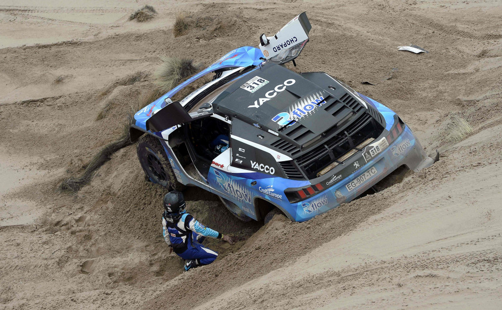 Romain Dumas and Alain Guehennec berjibaku membebaskan Peugeot-nya yang terjebak setelah menuruni gunungan pasir basah. 