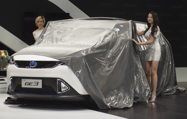 Dua wanita membuka selubung GAC CE3 yang merupakan crossover bermesin listrik. 