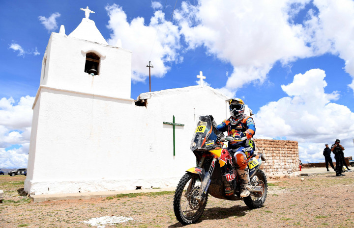 Matthias Walkner (Austria) melambatkan laju KTM-nya ketika melintasi sebuah perkampuangan di tengah etape 8.