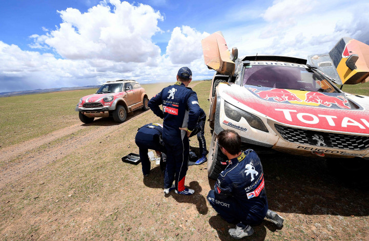 Sebastien Loeb (kanan) memeriksa kondisi suspensi Peugeot-nya di pos peristirahatan etape 8 antara Uyuni, Bolivia dengan Salta, Argentina.