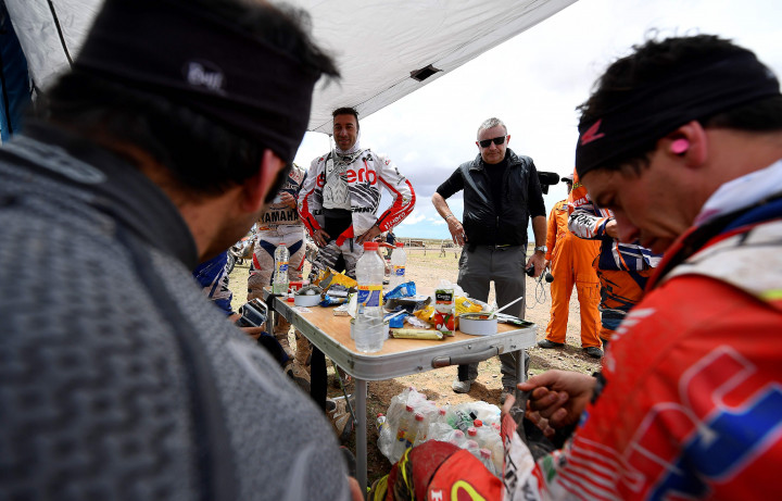 Direktur Reli Dakar, Etienne Lavigne (kacamata hitam) berbincang dengan beberapa pereli sepeda motor. Menyusul terjadi longsor akibat hujan lebat, etape 9 antara Salta ke Chilecito, Argentina, terpaksa dibatalkan.