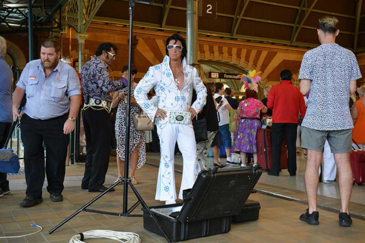 Penggemar berdandan dan bergaya ala Elvis Presley saat menunggu kereta api untuk membawa mereka menuju Kota Parkes, di sebuah stasiun KA di Sydney, Kamis (12/1/2017).