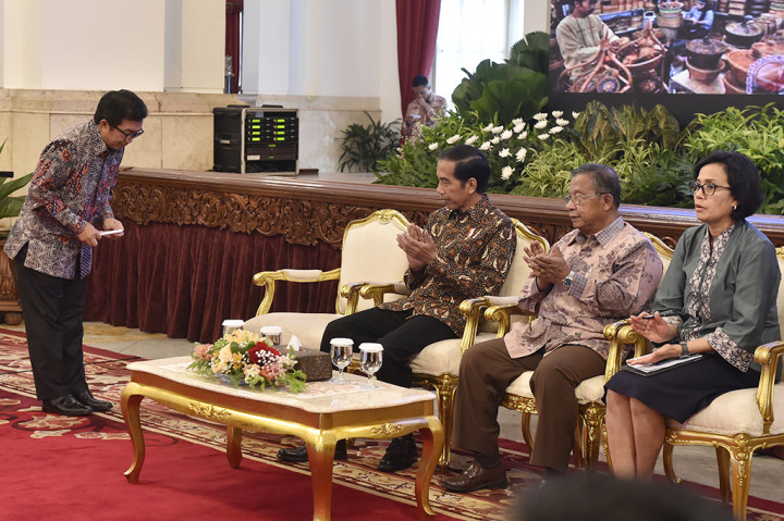 Presiden Jokowi (kedua kiri) didampingi Menko Perekonomian Darmin Nasution (tengah) dan Menteri Keuangan Sri Mulyani (kanan) usai mendengar pemaparan dari Ketua Dewan Komisioner Otoritas Jasa Keuangan (OJK) Muliaman D Hadad (kiri) pada pertemuan awal tahun pelaku industri jasa keuangan tahun di Istana Negara, Jakarta.