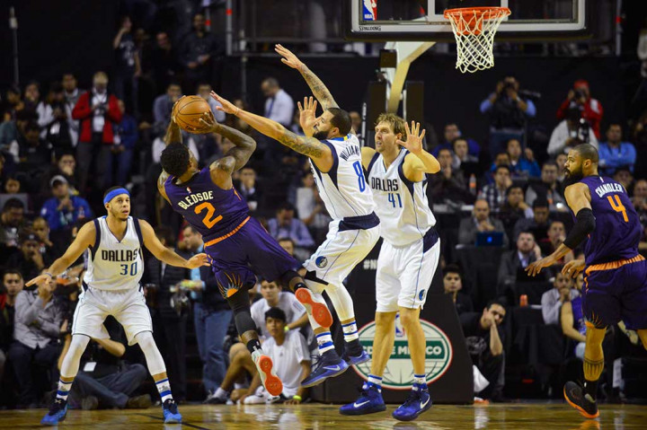 Point guard Dallas Mavericks Deron Williams berusaha mengeblok tembakan point guard Phoenix Suns Eric Bledsoe pada lanjutan laga NBA di Mexico City Arena, Mexico City, Jumat. 