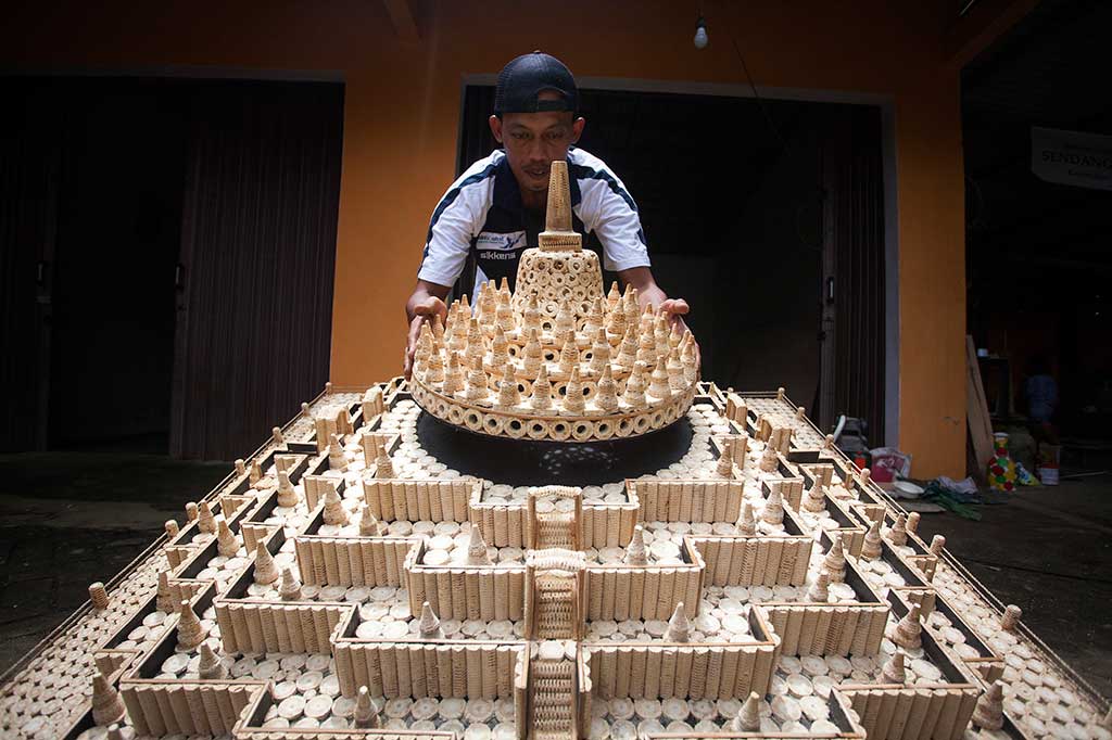 Perajin menyelesaikan pembuatan miniatur Candi Borobudur berbahan tongkol jagung, di Giowari Putra Craft, Minggir, Sleman.