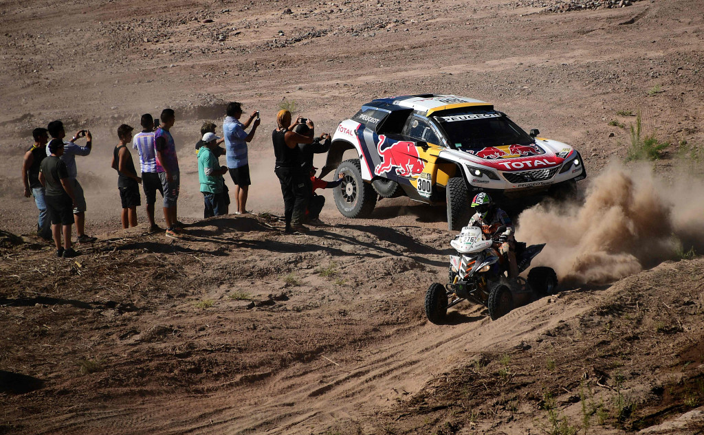 Peugeot yang dikendarai pasangan Prancis, Stephane Peterhansel - Jean Paul Cottret, mengejar quad ATV yang dipacu Zdenek Tuma (Czechnya) dalam etape 10.