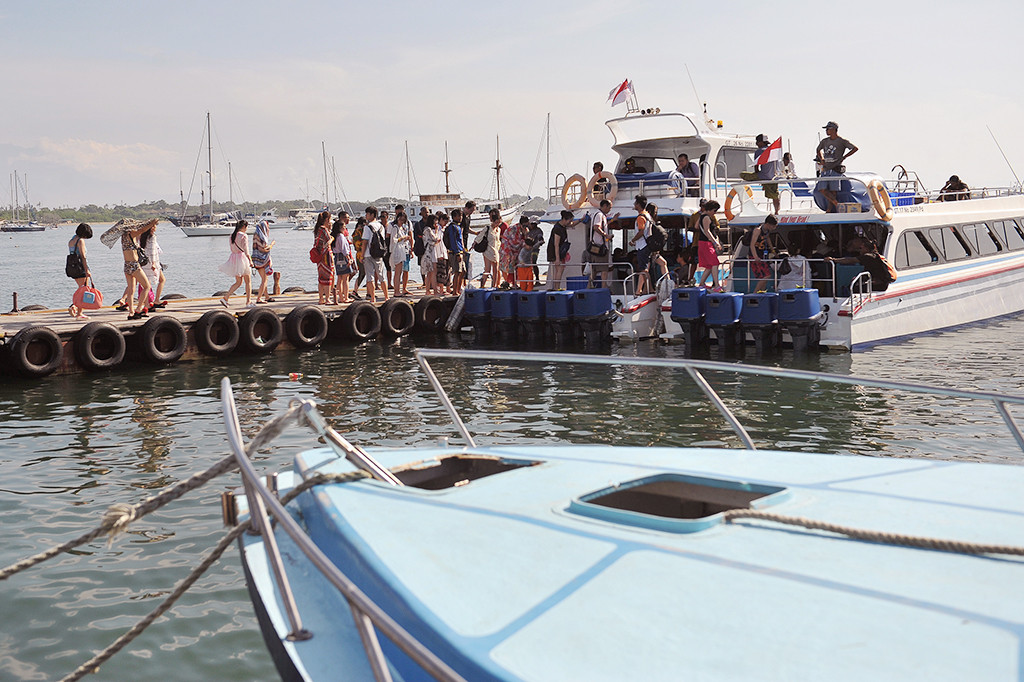 Sejumlah wisatawan berjalan di dermaga untuk berwisata dengan kapal laut di Serangan, Denpasar, Jumat (13/1/2017).
