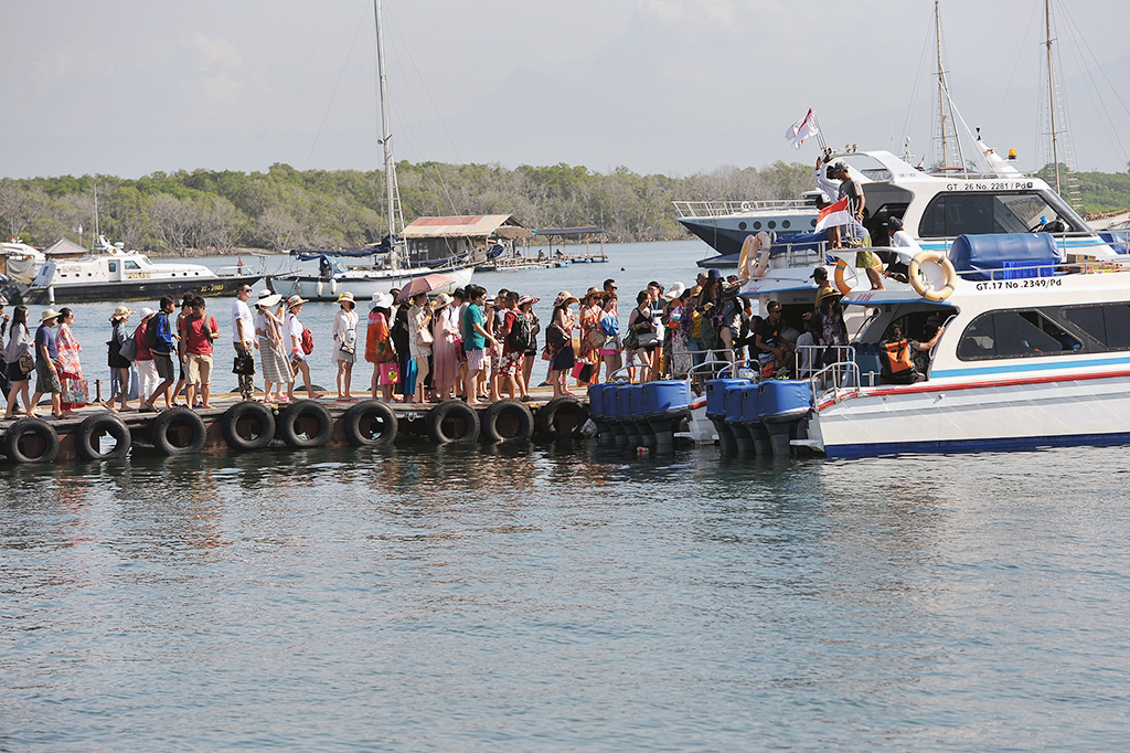 Sejumlah wisatawan berjalan di dermaga untuk berwisata dengan kapal laut di Serangan, Denpasar, Jumat (13/1/2017).