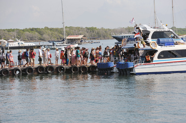Sejumlah wisatawan berjalan di dermaga untuk berwisata dengan kapal laut di Serangan, Denpasar, Jumat (13/1/2017).