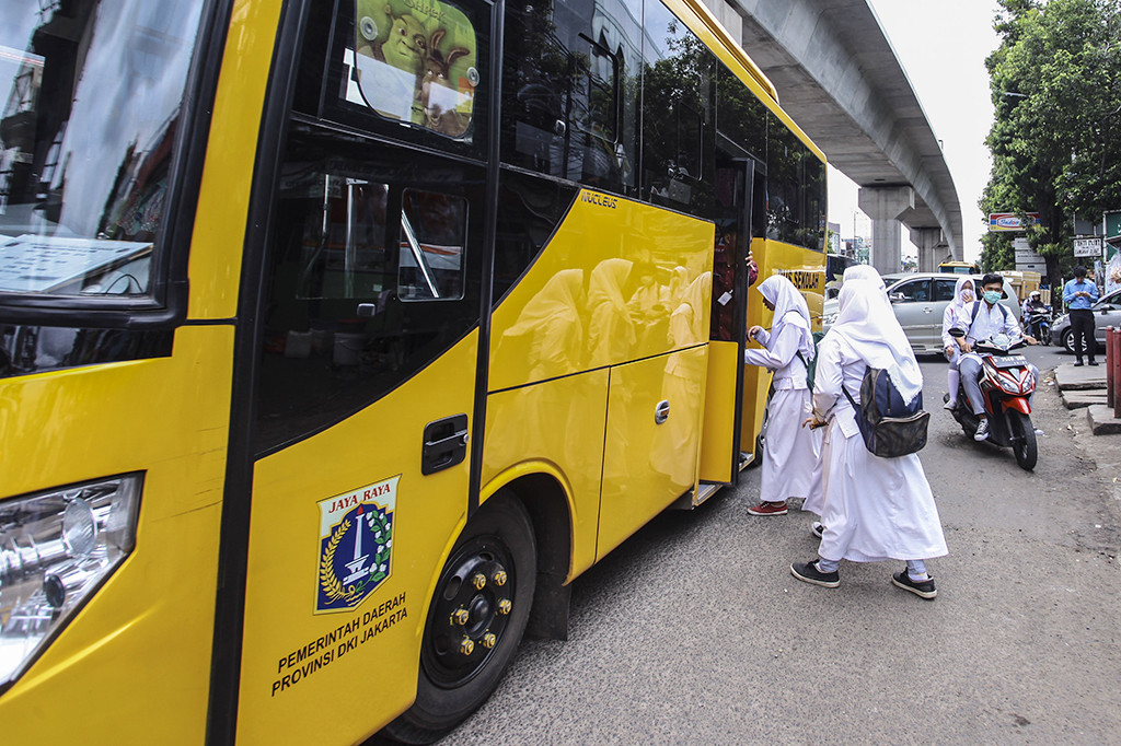 Pelajar menaiki armada bus sekolah gratis di Jakarta.