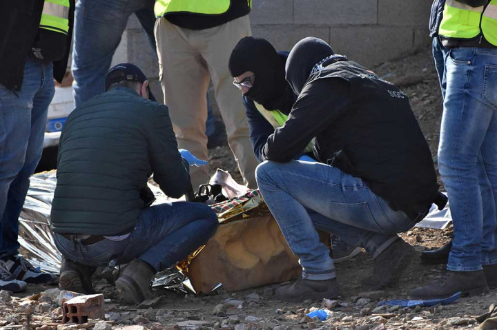 Polisi Spanyol memeriksa senjata yang ditemukan selama pencarian di sebuah tanah kosong di Cueta.
