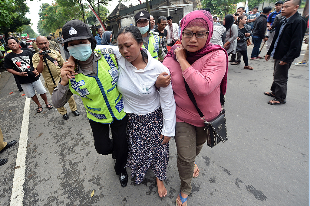 Anggota Polwan memapah seorang pedagang kaki lima (PKL) saat pembongkaran lapak oleh pihak berwenang di kawasan Jalan Mastrip Kota Blitar, Jawa Timur.