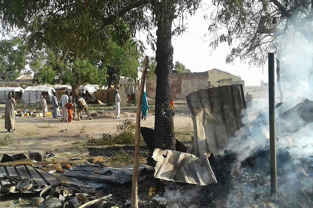 Asap mengepul dari sisa-sisa serangan jet tempur AU Nigeria di kamp pengungsi di negara bagian Borno, Selasa.