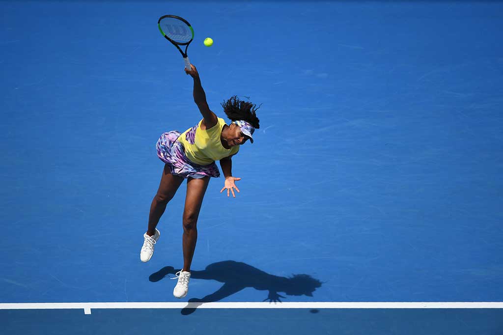 Venus Williams melancarkan servis ke arah petenis Swiss Stefanie Voegele.