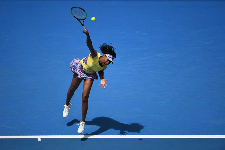 Venus Williams melancarkan servis ke arah petenis Swiss Stefanie Voegele.