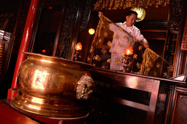 Warga keturunan Tionghoa membersihkan altar dewa di Klenteng Ban Hin Kiong, Manado, Sulawesi Utara, Rabu.