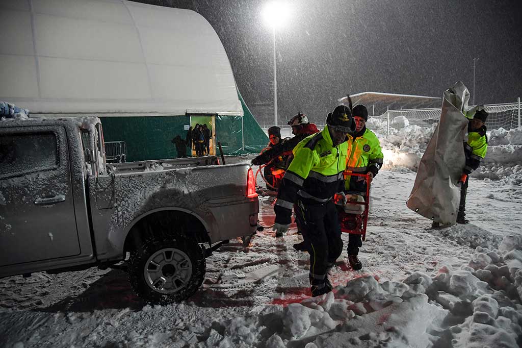Anggota Perlindungan Sipil Italia (Protezione Civile) membawa sebuah generator listrik untuk menerangi sebuah tenda besar di lapangan olahraga di Montereale.