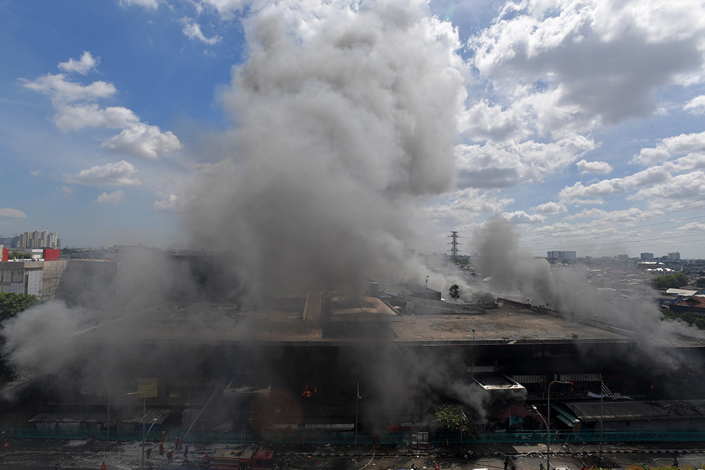 Asap membumbung ke udara dari bangunan Blok I dan Blok II yang terbakar di Pasar Senen, Jakarta.