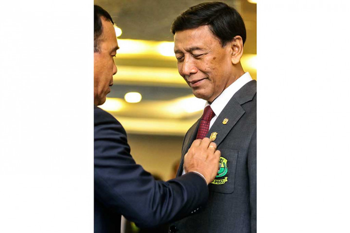 Ketua KONI Pusat Tono Suratman menyematkan pin kepada Ketua Umum PP PBSI Wiranto.