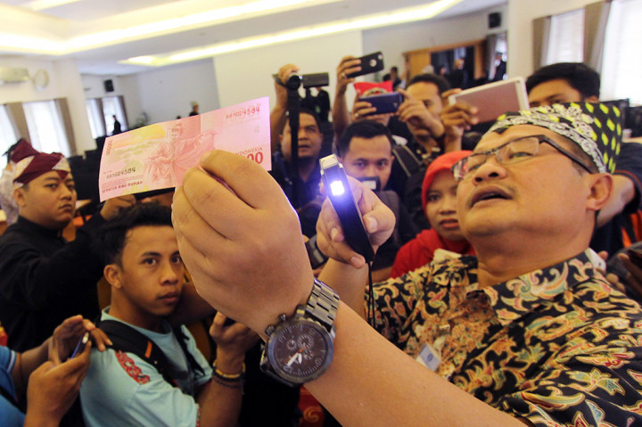 Kepala Perwakilan Bank Indonesia (BI) Jember Achmad Bunyamin (kanan) mensosialisasikan uang rupiah desain baru di Kantor Bupati Banyuwangi, Jawa Timur.