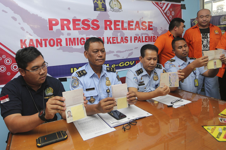 Kepala Imigrasi Kelas I Palembang Budiono (kedua kiri) didampingi Kasi Wasdakim Jompang (ketiga kiri) menunjukkan paspor milik WNA ilegal di Kantor Imigrasi Klas 1A Palembang, Sumatera Selatan.