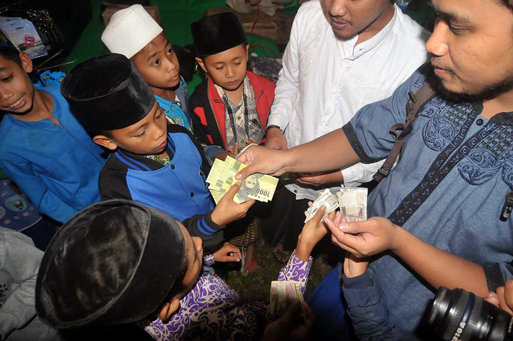 Petugas melakukan transaksi penukaran uang baru NKRI saat sosialisasi dan penukaran uang tahun emisi 2016 di Pondok Pesantren At Tauhidiyah Desa Cikura, Kabupaten Tegal, Jawa Tengah, Jumat.