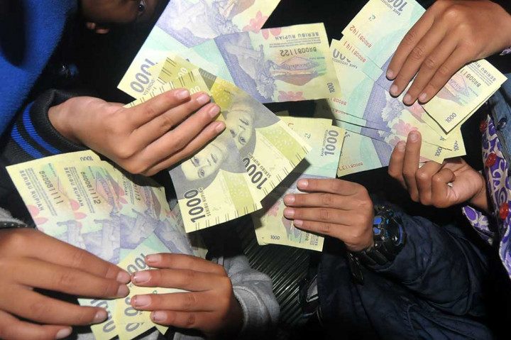 Santri memperhatikan uang baru NKRI saat sosialisasi dan penukaran uang tahun emisi 2016 di Pondok Pesantren At Tauhidiyah Desa Cikura, Tegal.