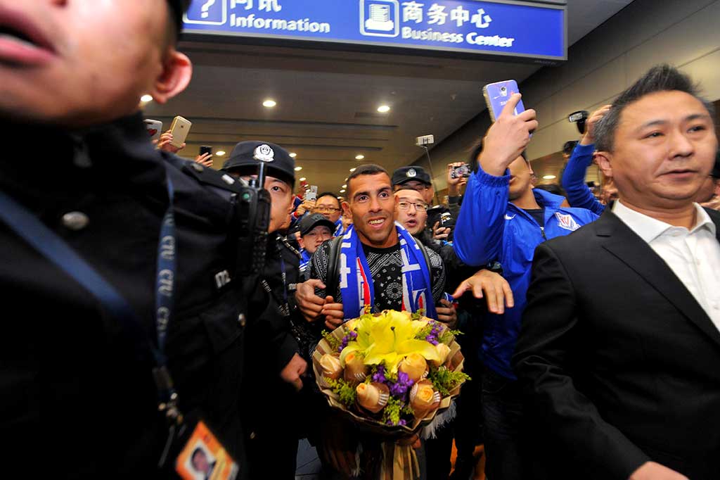 Carlos Tevez dengan pengawalan ketat tiba di Bandara Internasional Pudong, Shanghai, Kamis.