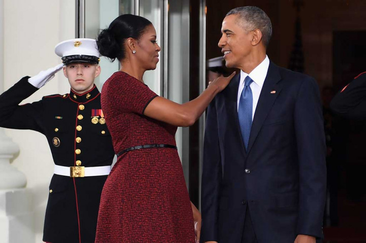 Michelle merapihkan jas yang dikenakan Obama. Kemesraan memang selalu ditampilkan oleh pasangan tersebut. AFP/Jim Watson