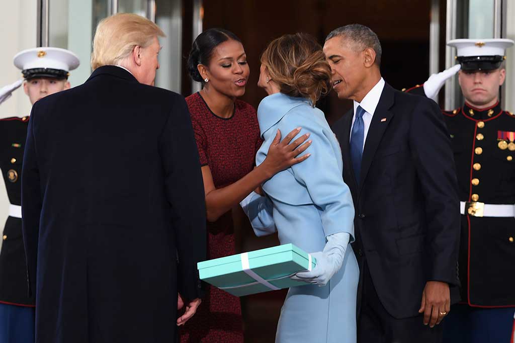 Michelle menyambut Melania dengan ciuman disaksikan Obama dan Trump. AFP/Jim Watson