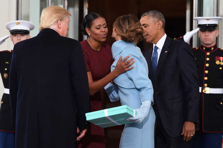 Michelle menyambut Melania dengan ciuman disaksikan Obama dan Trump. AFP/Jim Watson