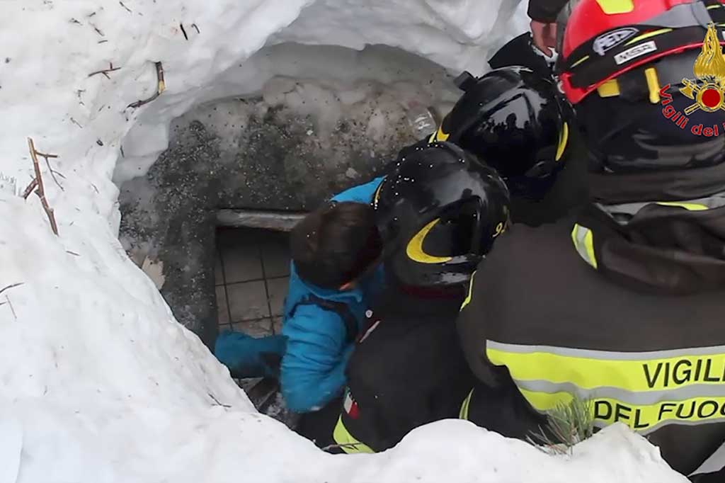 Tim SAR mengangkat seorang anak dari reruntuhan Hotel Rigopiano, dekat desa Farindola, lereng gunung Gran Sasso, dua hari setelah terkubur longsoran salju, Jumat.