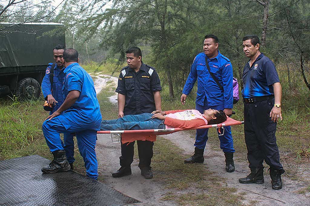Tim SAR Malaysia mengevakuasi korban selamat tenggelamnya kapal pengangkut TKI di Perairan Tanjung Rhu, Mersing, Johor Bahru, Senin. Dua orang ditemukan selamat, 10 tewas, dan 30 hilang akibat kecelakaan tersebut.