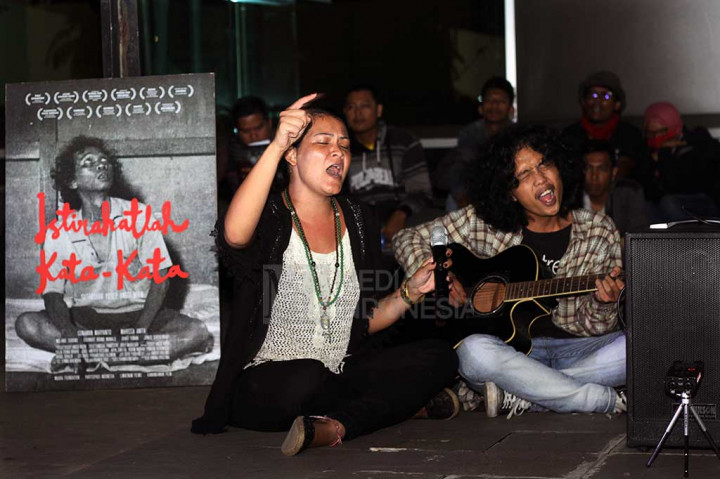 Putra penyair Wiji Thukul, Fajar Merah (kanan) bersama musisi yang juga aktivis Melanie Subono menyanyikan sebuah lagu ketika menghadiri pembacaan puisi karya Wiji Tukul di Taman ismail Marzuki, Jakarta, Selasa.
