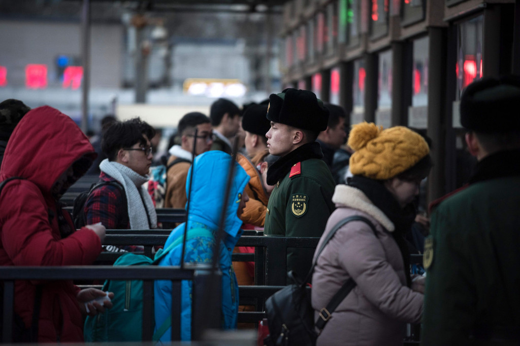 Tentara berjaga di depan loket penjualan tiket untuk menjaga warga antrian tetap tertib.