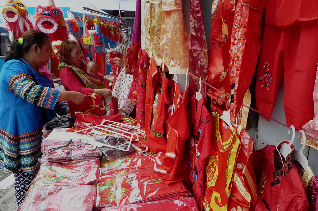 Calon konsumen memilih pakaian khas Tionghoa di Pasar Imlek Semawis, Semarang, Jawa Tengah.