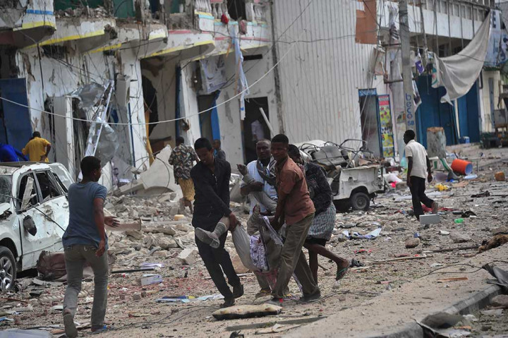 Warga mengevakuasi korban luka-luka akibat ledakan bom dan serangan terhadap hotel di Mogadhishu, Somalia, Rabu.