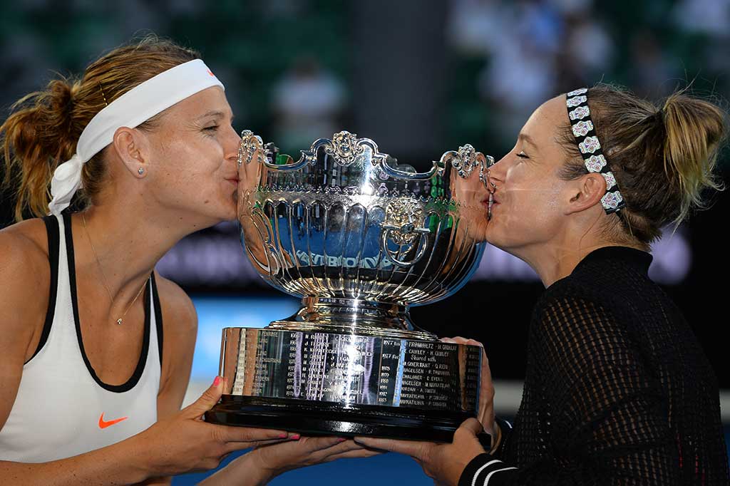 Mattek-Sands/Safarova mencium trofi yang baru saja mereka raih.