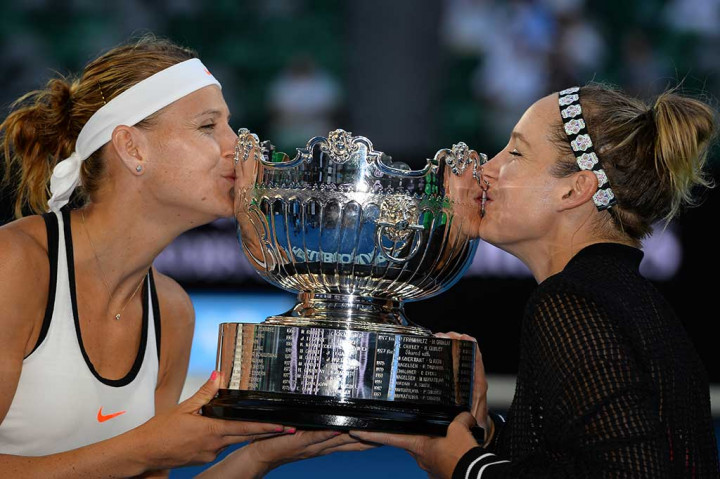 Mattek-Sands/Safarova mencium trofi yang baru saja mereka raih.