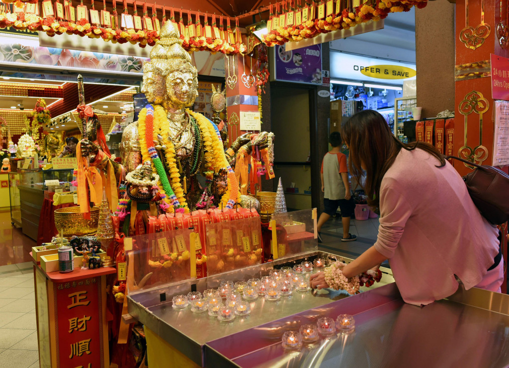 Seorang umat Buddha berdo'a di depan patung Dewi Kwan Im. Dewi Kwan Im merupakan dewi welas asih dan kesuburan. 