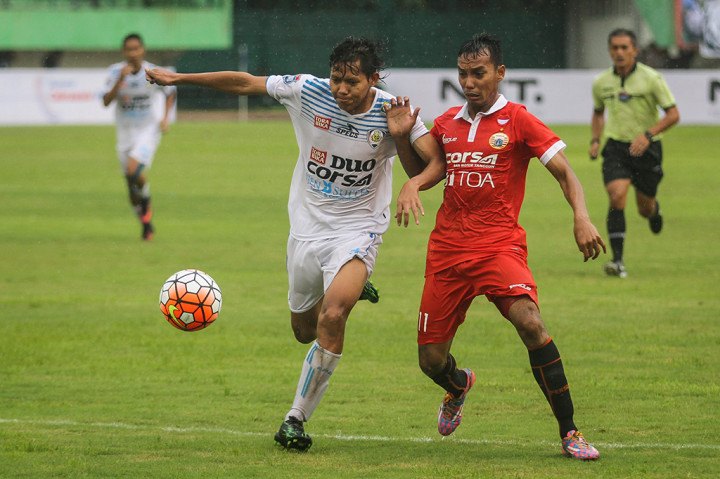 Pemain Arema FC, Adam Alis (kiri) berebut bola dengan pemain Persija Jakarta, Novri Setiawan.